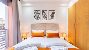 Una habitación de hotel con una cama, dos mesitas de noche, un armario y obras de arte en la pared.