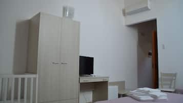 Quarto com cama, escrivaninha, guarda-roupa e ar condicionado.