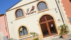 A building with a sign reading "Il Veliero" and an ATM on the ground floor. - Il Veliero (Pachino)