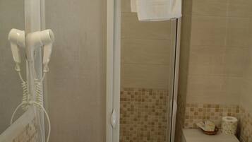 Baño con ducha, lavamanos y espejo.