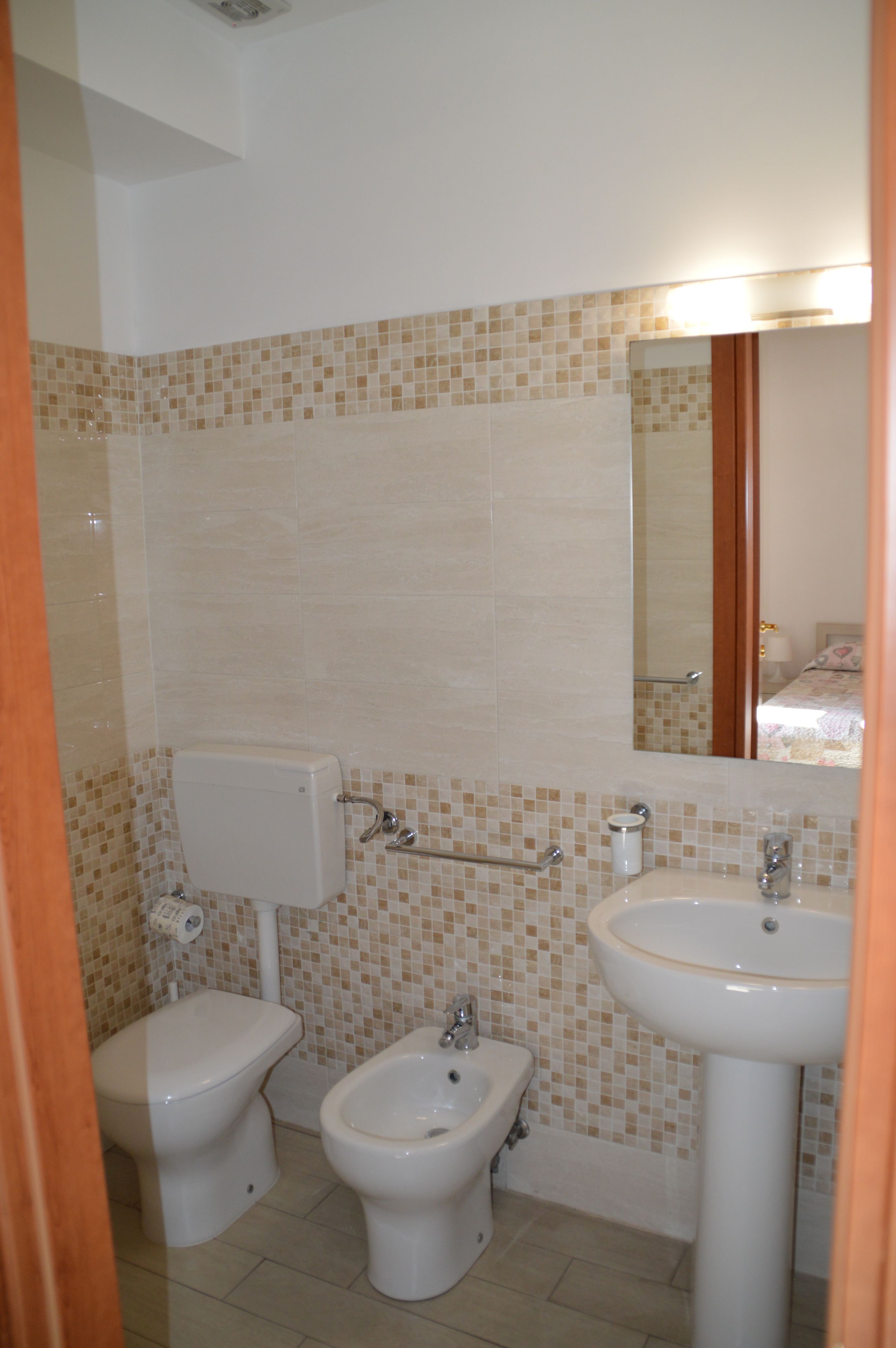 Un baño con inodoro, bidé y lavamanos.