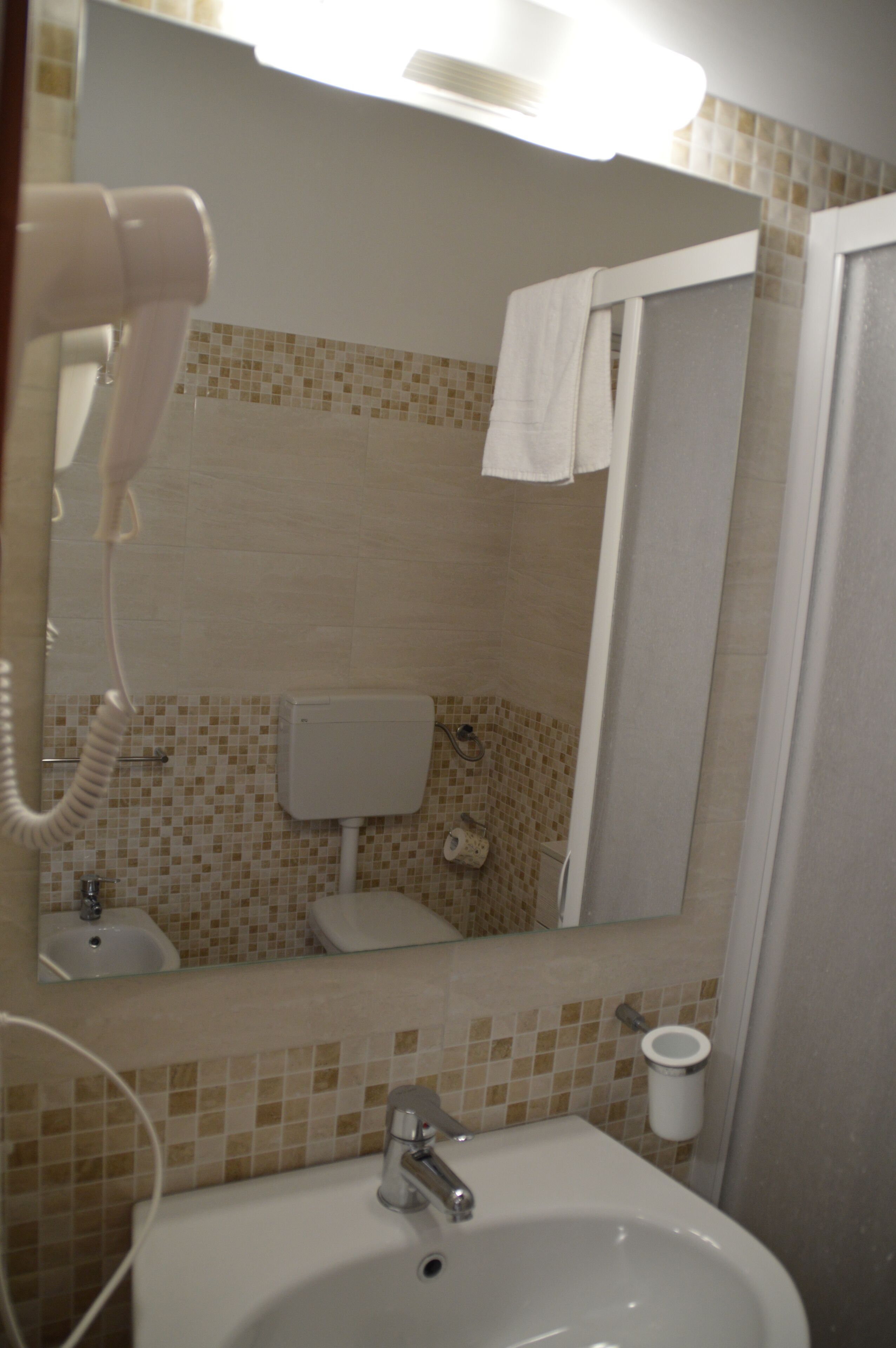 A bathroom with a sink, mirror, and a hairdryer.