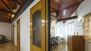 A room with wooden floors, a wooden door, a dining table with chairs, a white desk, and a wooden cabinet. - Belgrade Center Apartment V (Belgrade)