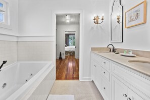 A modern bathroom with a bathtub, vanity, and a mirror.