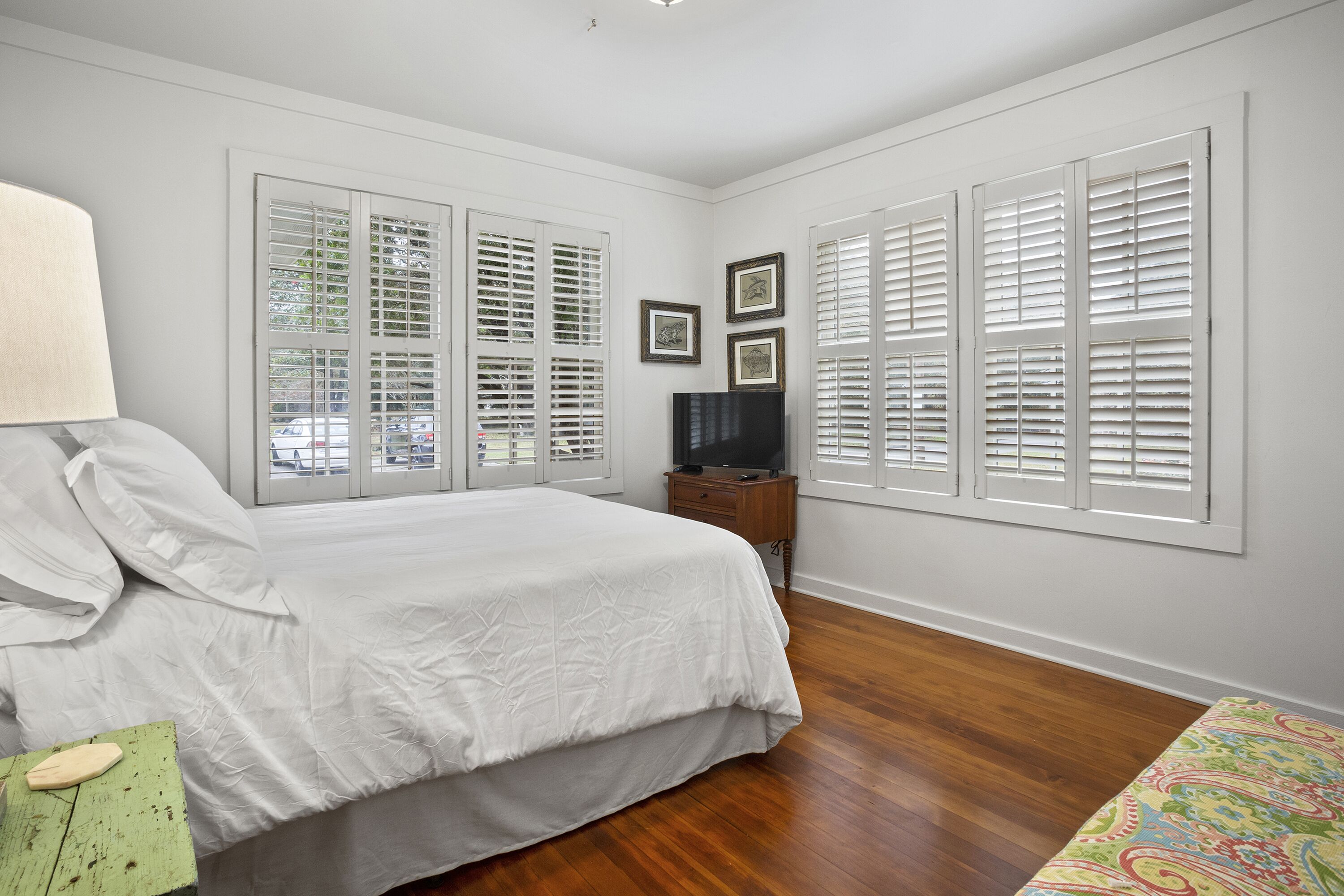 A bedroom with a bed, a TV, and a dresser.