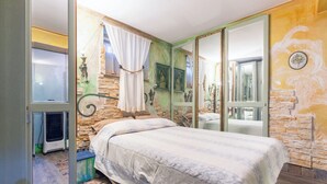 Ein Schlafzimmer mit Bett, Fenster, Heizung und Spiegel.