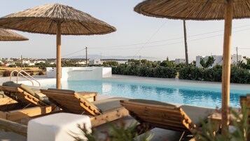 Una piscina al aire libre de temporada, sombrillas