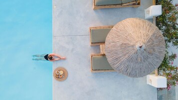 Una piscina al aire libre de temporada, sombrillas