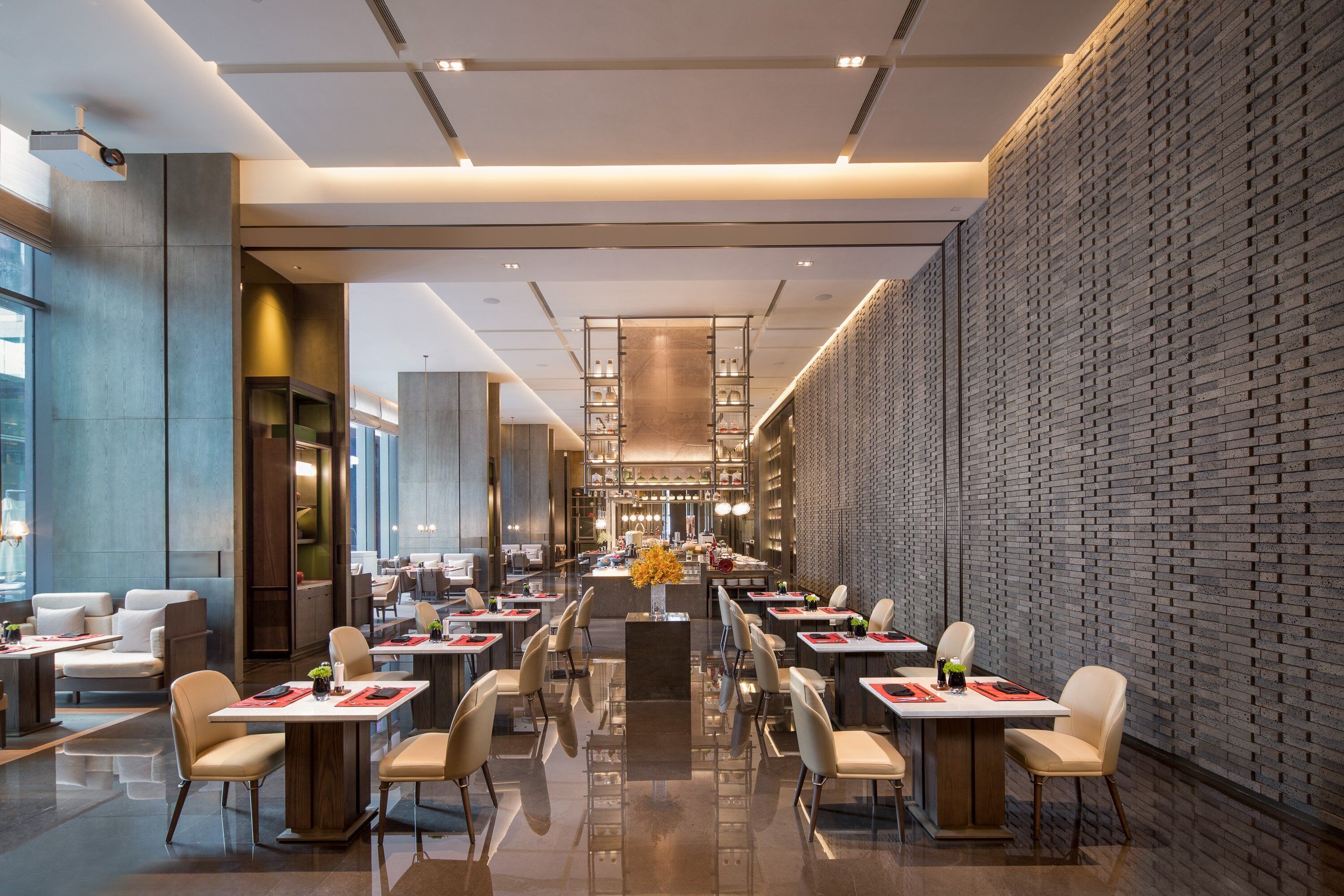 Un restaurante moderno con una barra larga, varias mesas y sillas.