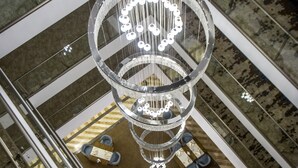 A multi-level atrium with a central chandelier, glass railings, and seating areas. - Willmont Hotel (Balikesir)