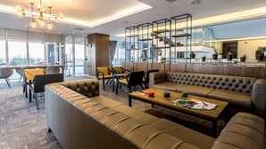 A modern lounge area with leather sofas, a wooden coffee table, and a unique chandelier. - Willmont Hotel (Balikesir)