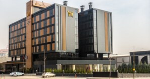 A modern hotel building with a prominent 'W' logo, multiple floors, and a glass facade.