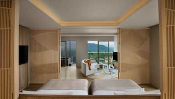 A modern hotel room with a balcony, wooden decor, and a view of the mountains.