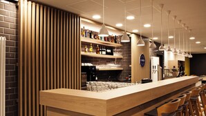 A bar area with a wooden counter, bar stools, and shelves stocked with bottles. - Holiday Inn Express Mulheim - Ruhr by IHG (Muelheim an der Ruhr)