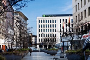 Un bâtiment de la chaîne Holiday Inn Express, doté d’une façade moderne, de grandes fenêtres et d’une enseigne bien visible.