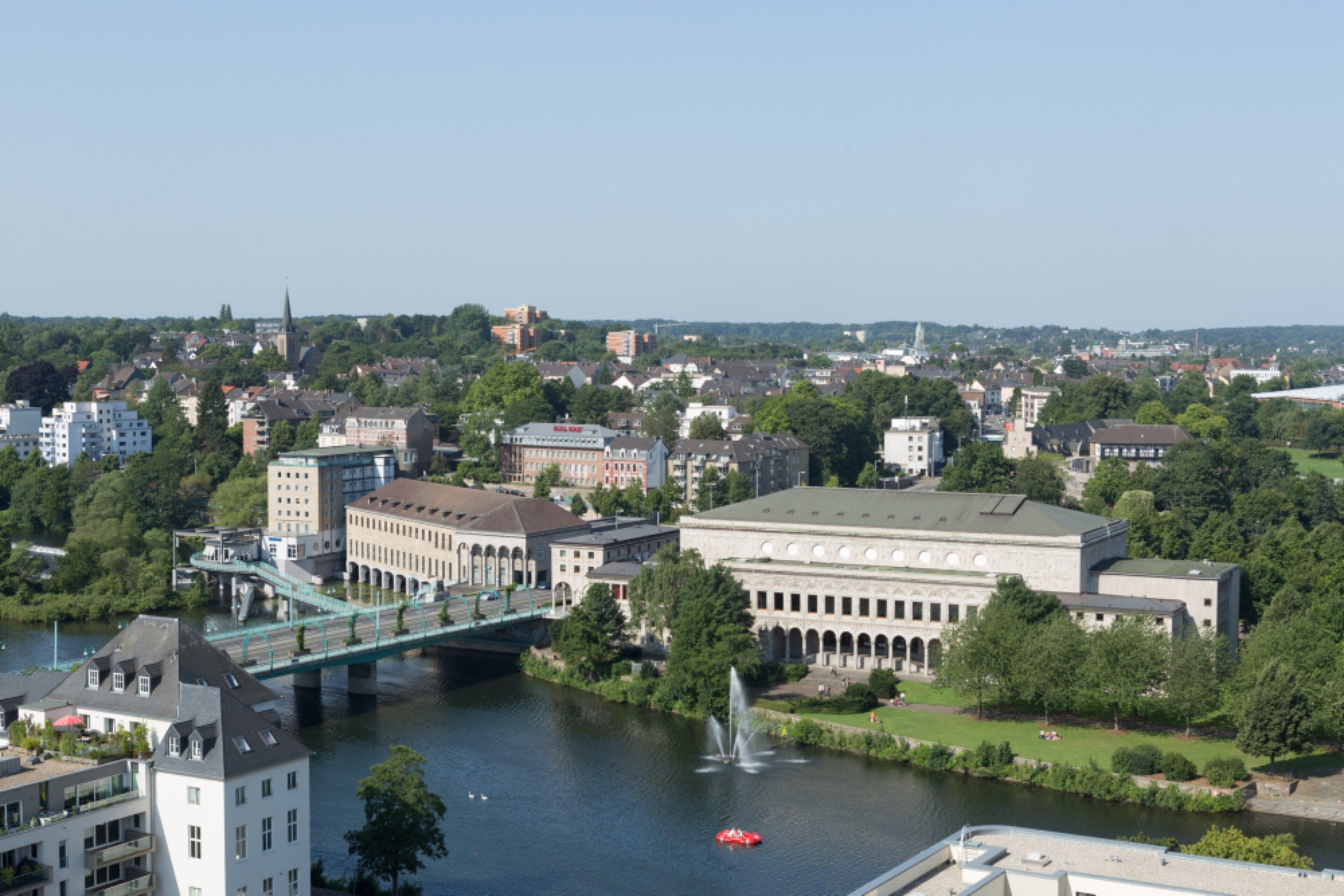 A riverside view of a city with a prominent building with a large dome and a bridge over the river.