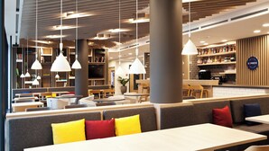 A modern cafe with seating arrangements, pendant lighting, and a bar area. - Holiday Inn Express Mulheim - Ruhr by IHG (Muelheim an der Ruhr)