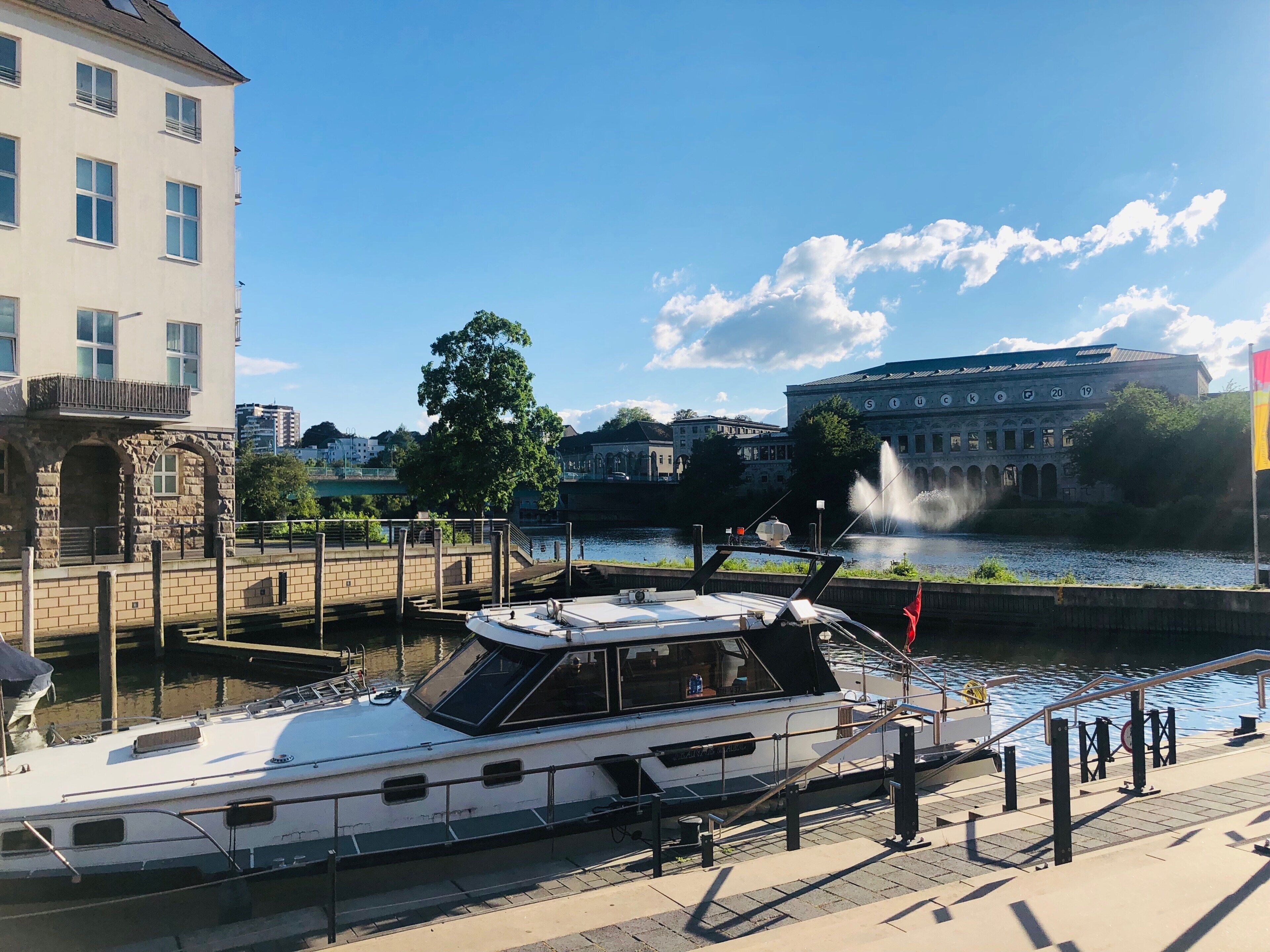 A boat docked at a waterfront with a building in the background.