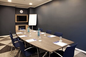 A conference room with a long table, chairs, a clock, and a whiteboard. - Holiday Inn Express Mulheim - Ruhr by IHG (Muelheim an der Ruhr)