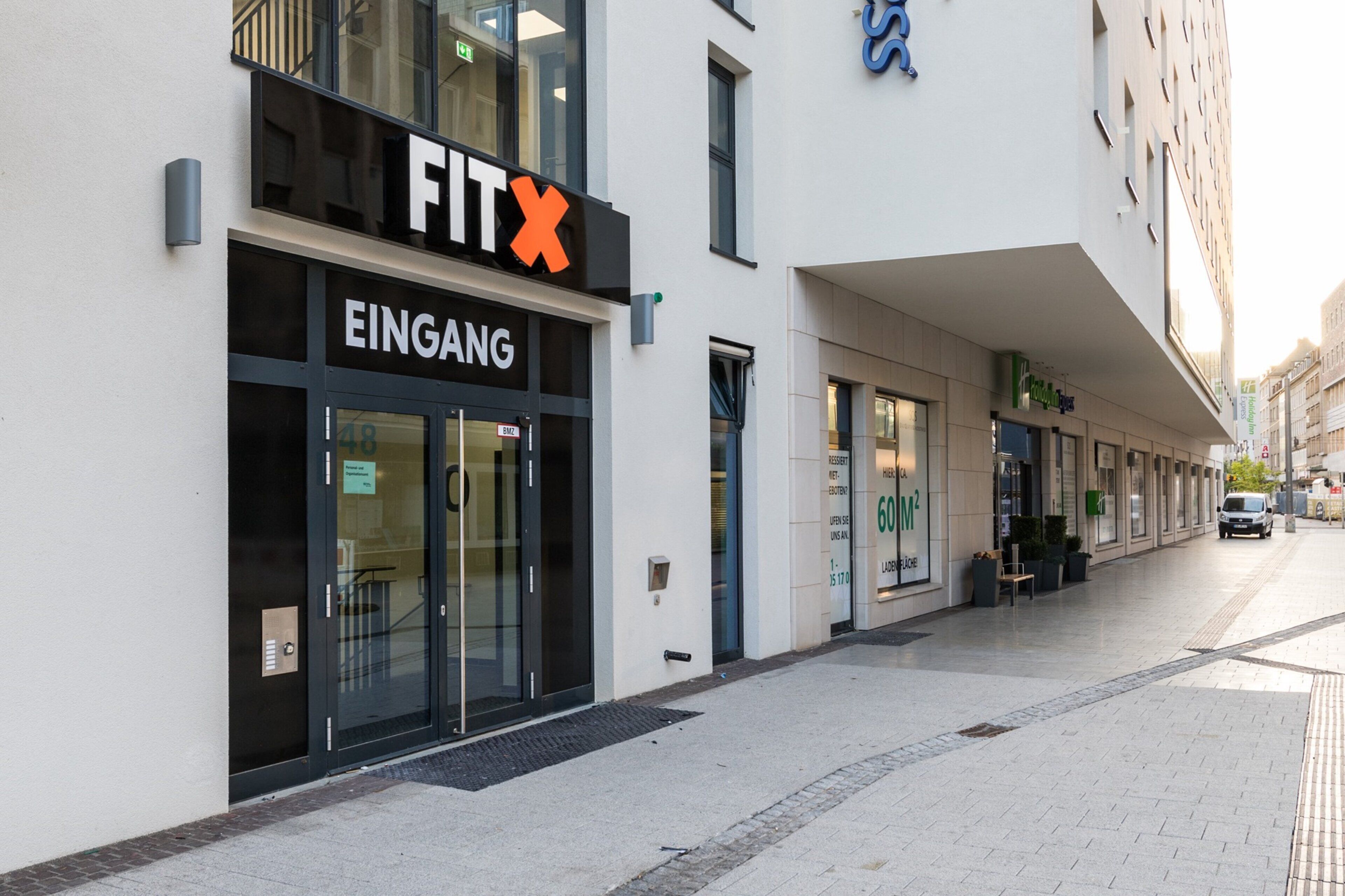 Un edificio comercial con un letrero que dice 'FIT' e 'INGRESOS' indicando una entrada.