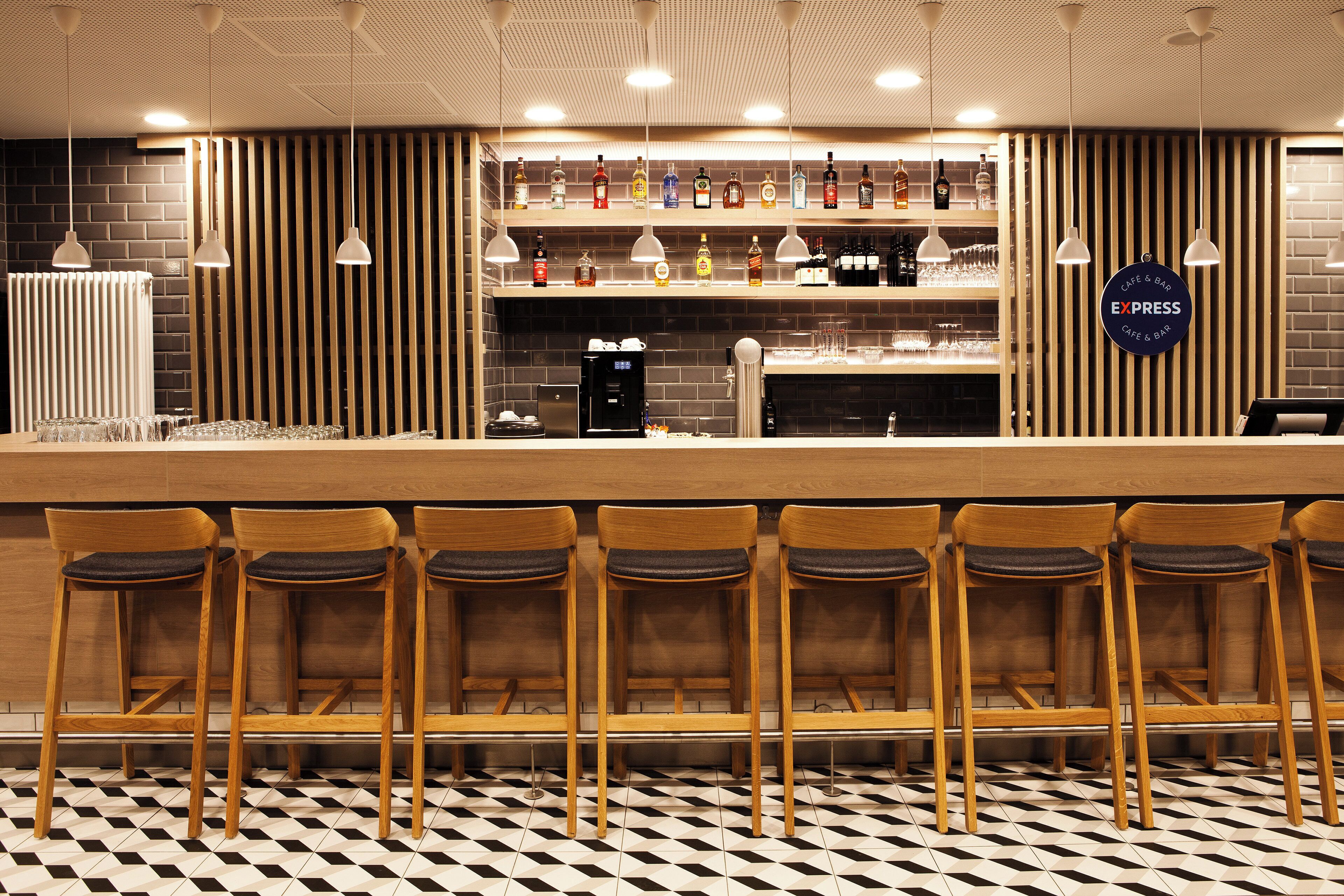 A bar area with wooden chairs and a coffee machine.