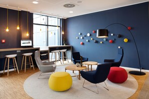 Contemporary office space with seating options, coffee table, and mounted television.