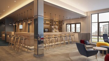 Zona de bar moderna con mostradores de madera, taburetes y lámparas colgantes.