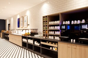 Welcome to our lobby, featuring a reception desk, comfortable seating, and a beverage station.
