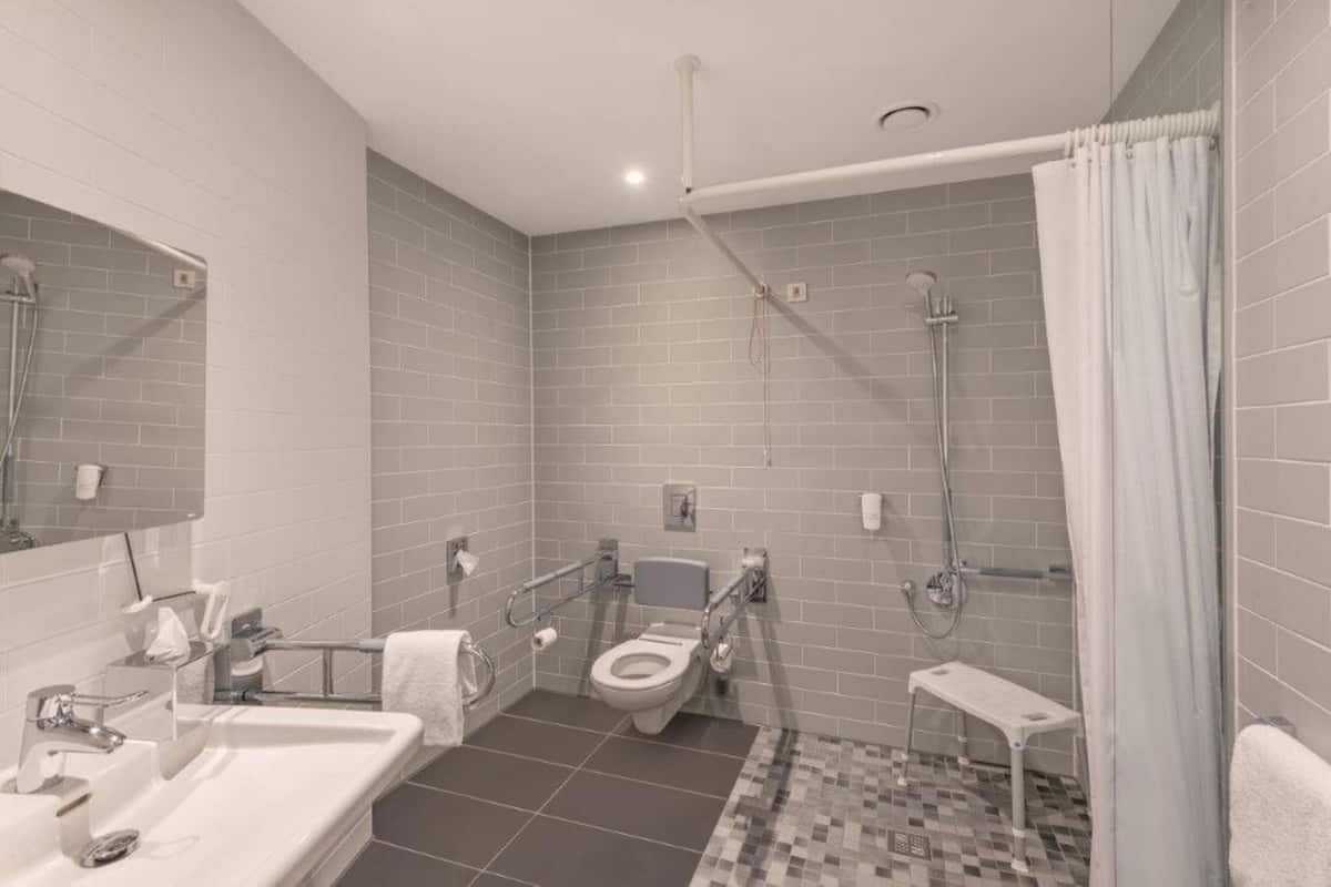 A modern bathroom with a toilet, sink, and shower.
