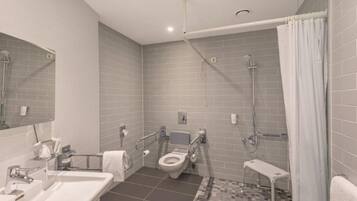 A modern bathroom with a toilet, sink, and shower.