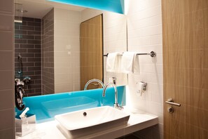 Enjoy a refreshing soak in the large bathtub, complemented by a sleek sink and glass shower enclosure.