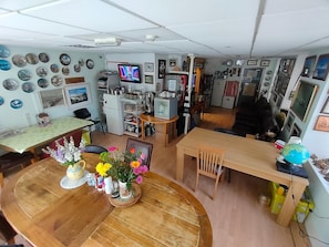 A compact living space with a dining area, kitchen, and a TV. - Plymouth Backpackers Hotel (Plymouth)