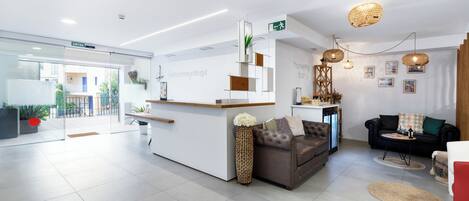 Ett modernt receptionsområde med en receptionsdisk, en sittgrupp med soffor och ett soffbord.