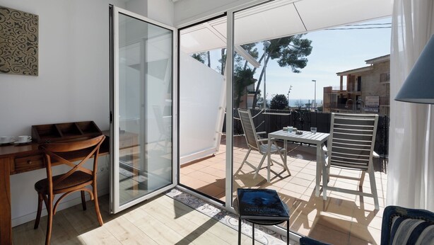 Een moderne kamer met een schuifglazen deur naar een terras.
