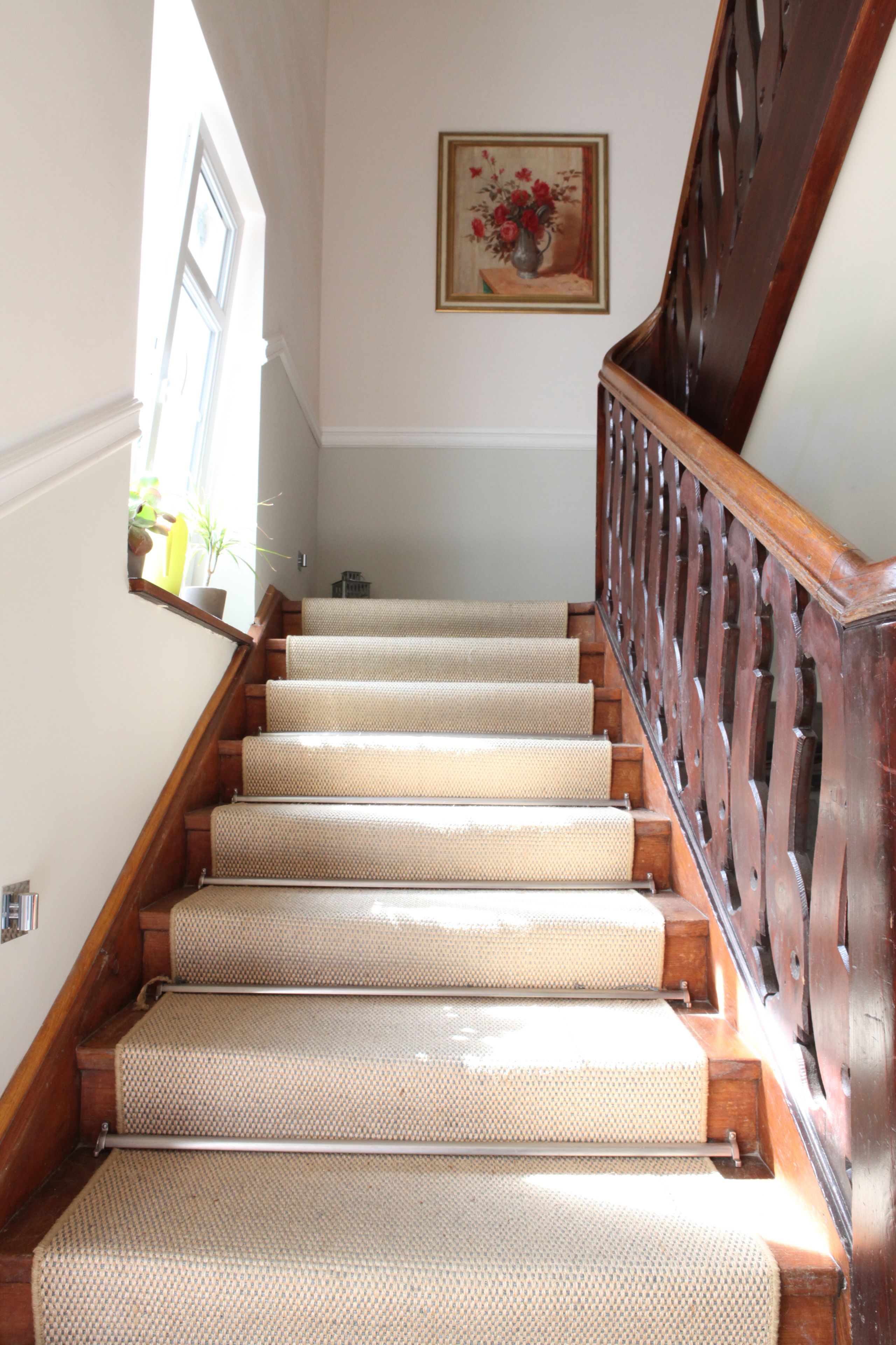 A staircase with wooden steps and a handrail, leading to an upper floor.