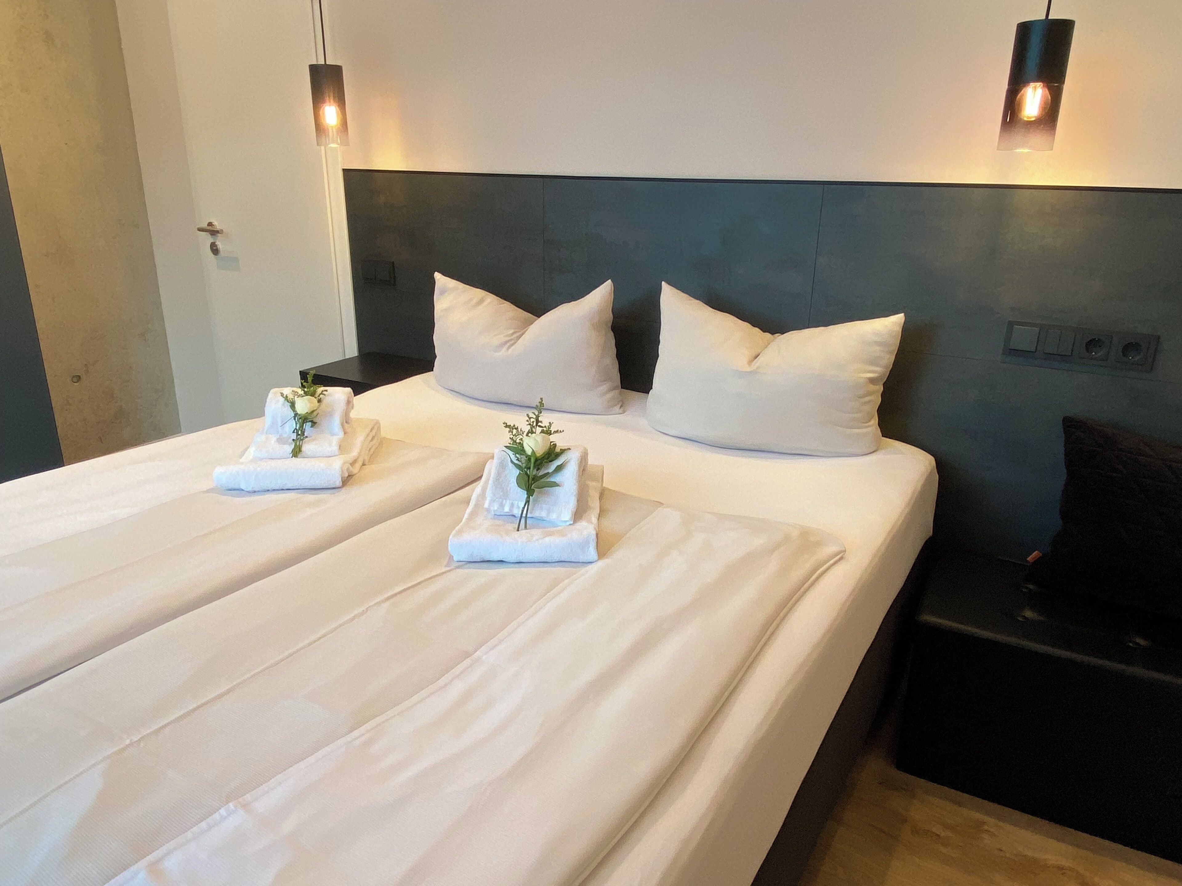 Ein Hotelzimmer mit einem großen Bett, zwei Kissen und zwei Nachttischen.