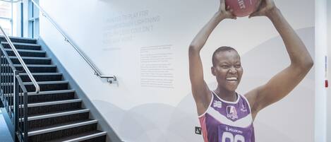 A wall with a basketball player in a purple jersey with the number 35, a staircase, and a quote about playing basketball.