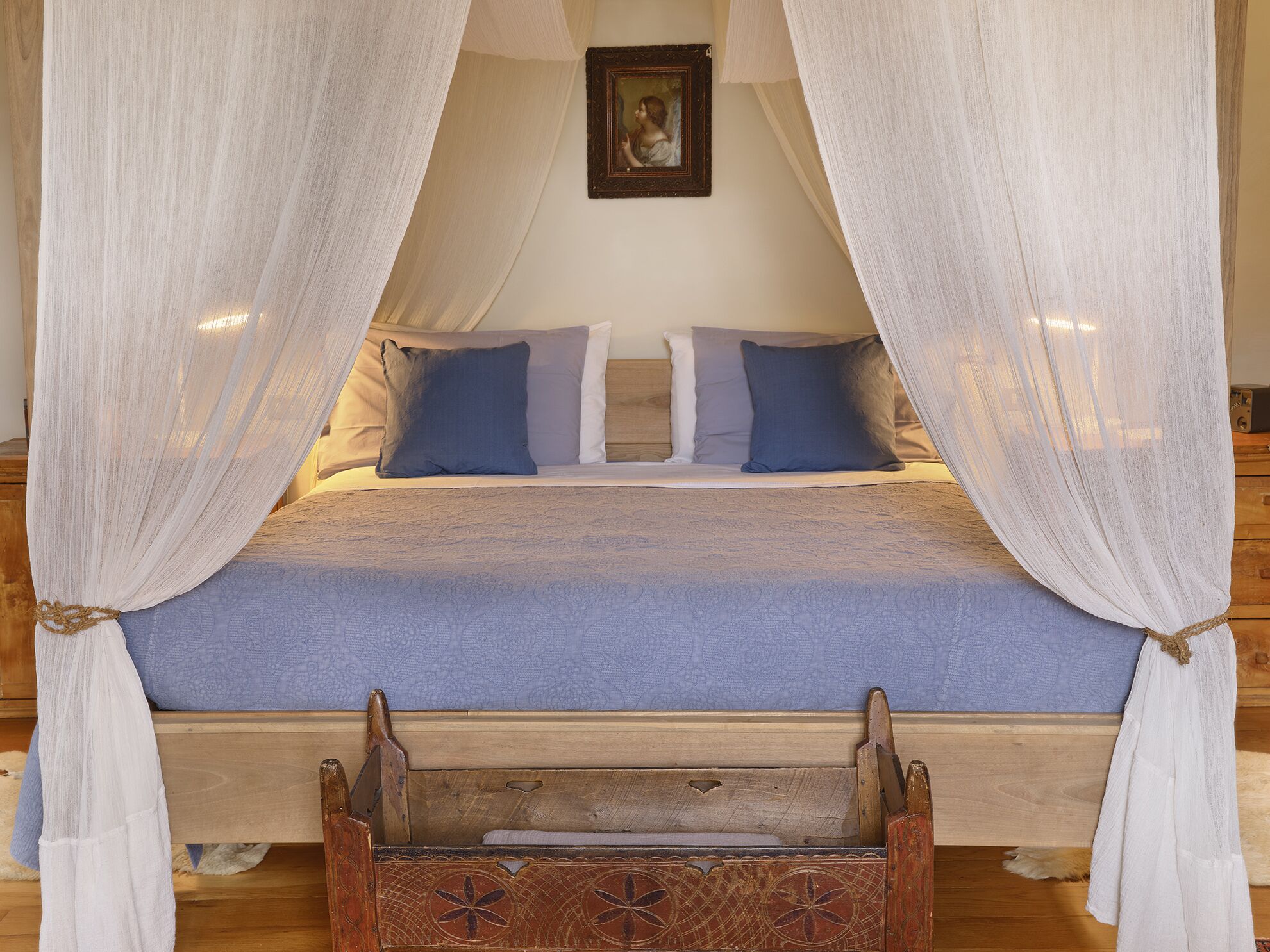 A bed with a canopy, pillows, and a wooden headboard.