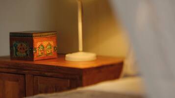 Une table de chevet avec une lampe et une boîte décorative.