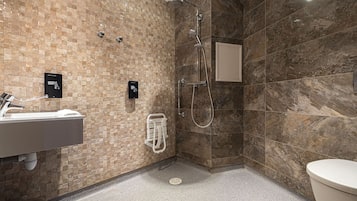 A modern bathroom with a shower, a sink, and a toilet.