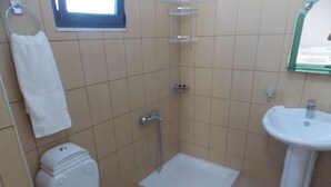 A small bathroom with a toilet, a shower, and a sink. - Amber Apartments (Sarandë)