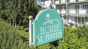 A sign for Hotel St. Martin with a clear view of the building's exterior, including balconies and outdoor seating. - Hotel St. Martin (Marktoberdorf)