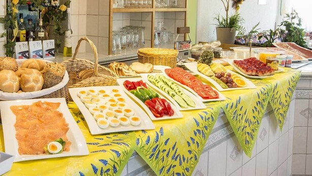 A breakfast buffet with various food items and beverages. - Hotel St. Martin (Marktoberdorf)