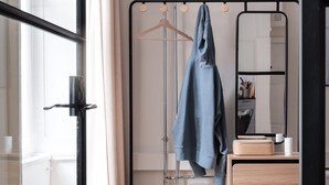 A modern bathroom with a glass shower enclosure, a wooden vanity with a mirror, and a towel rack with a blue towel. - The Brewer apartments by Daniel&Jacob’s (Copenhagen)