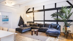 A modern living room with a sectional sofa, a round coffee table, and a large potted plant.