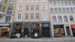 A building with a 'Letz Sushi' restaurant on the ground floor, featuring large windows and a black entrance.