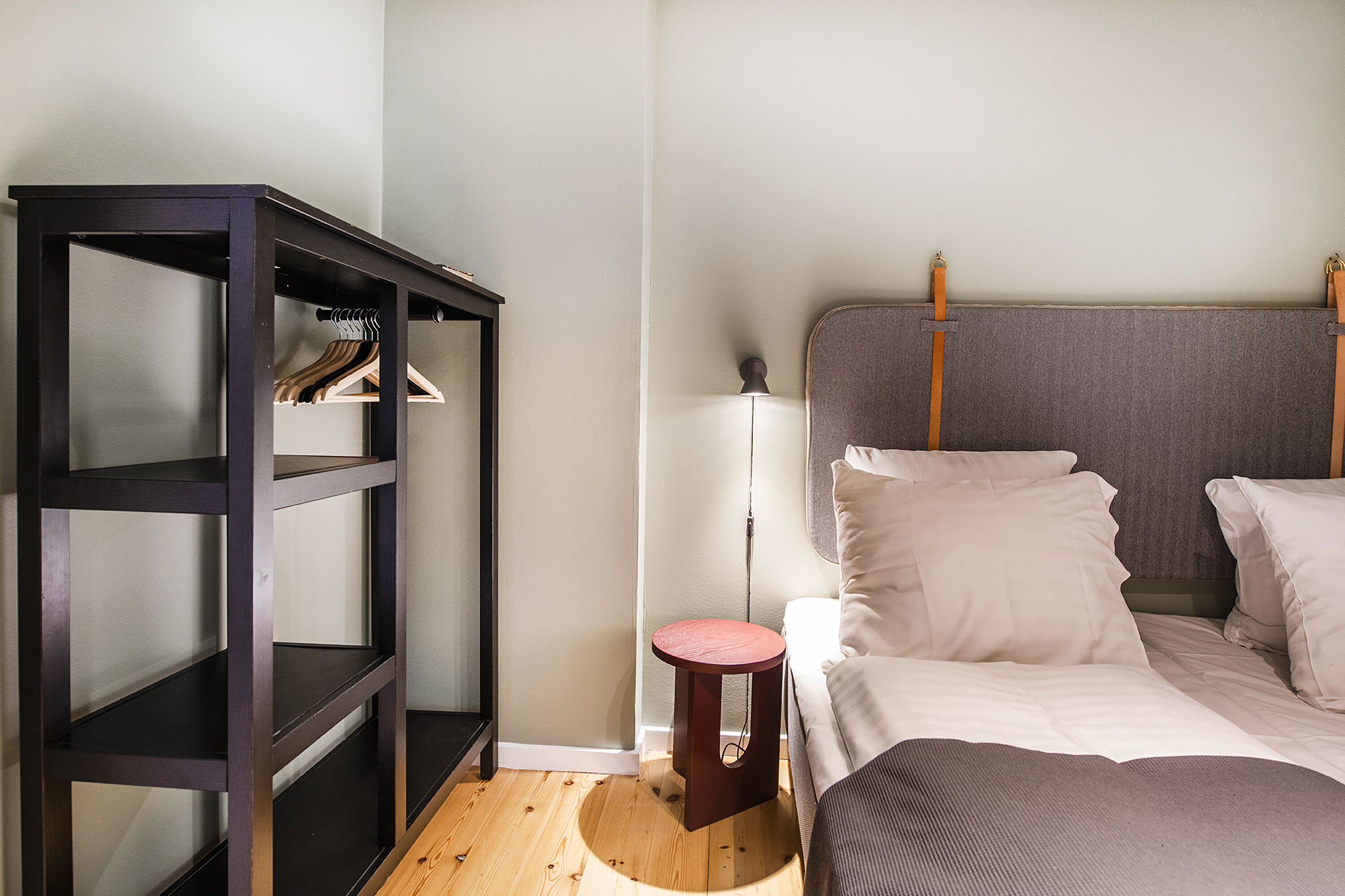 Een slaapkamer met een bed, een kast en een nachtkastje.