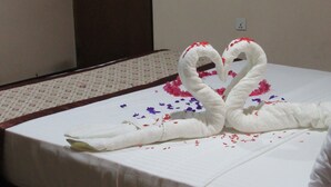 A bed with a white sheet and a decorative swan arrangement made of towels. - Kalamatiya Bird Sanctuary (Kalametiya)