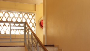 A staircase with a wooden handrail and beige steps. - Hotel Maroua Palace (Maroua)
