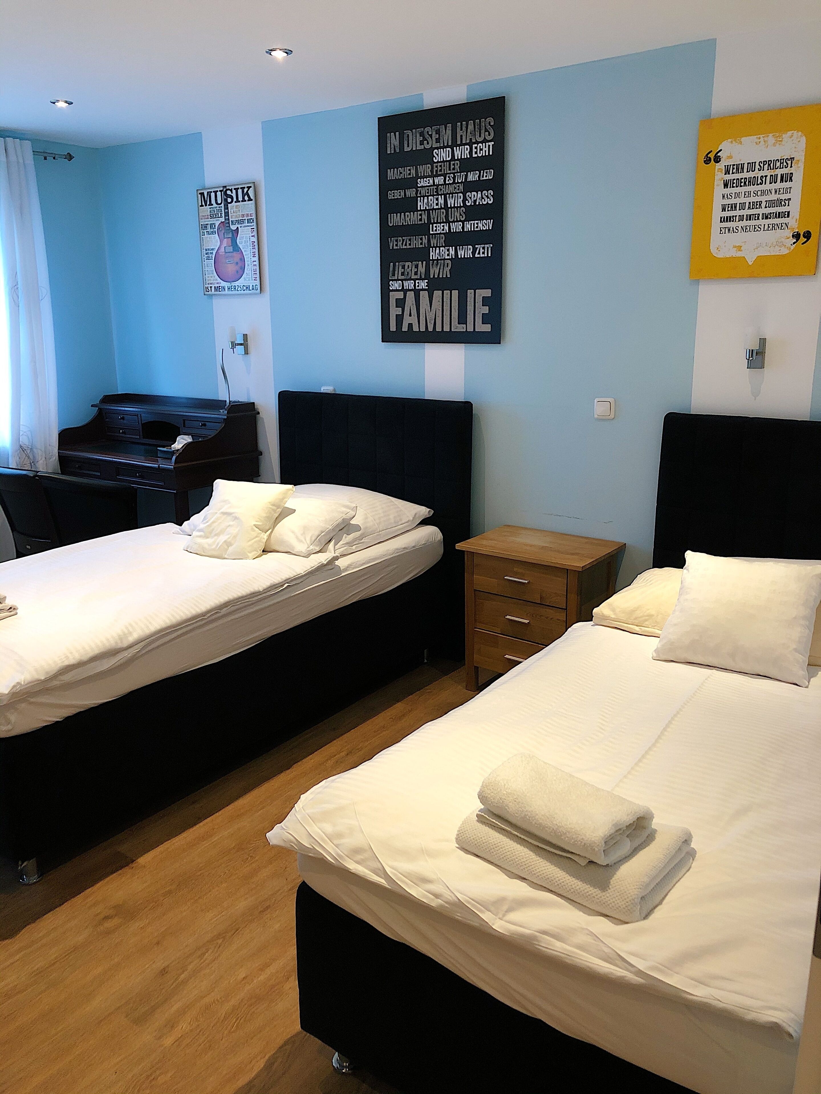 Una habitación de hotel con dos camas, un escritorio y un piano.